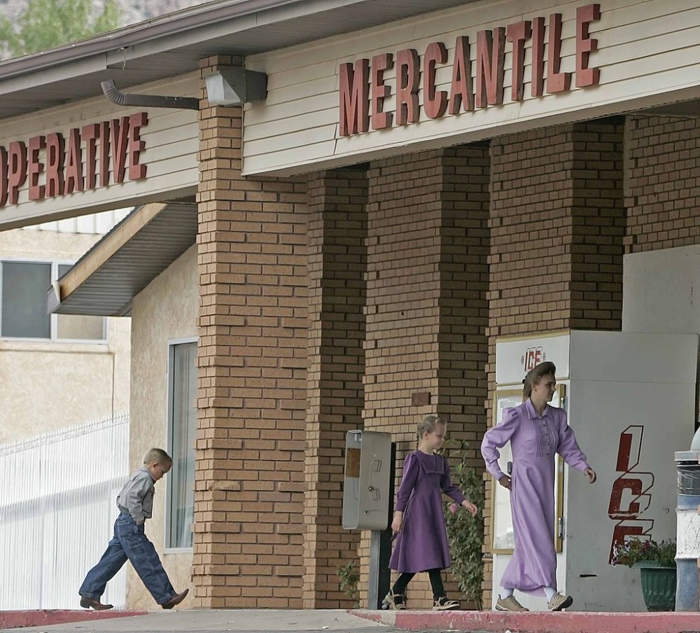 A woman and two children walk into a local store in Colorado City, Arizona. (Photo by George Frey/Getty Images)