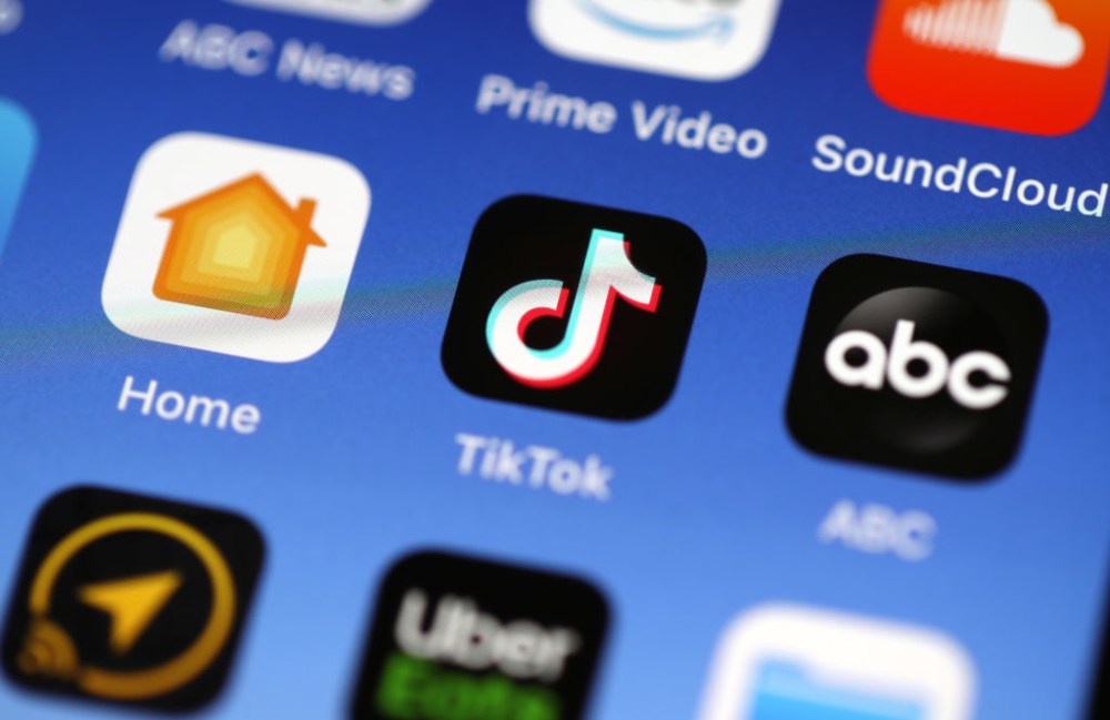 The Tik Tok app is displayed on an Apple iPhone