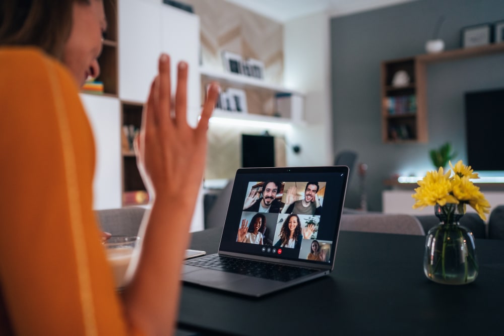 Woman using laptop for video conference to connect with her family, colleagues and friends from home