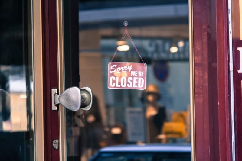 A business displaying a sign stating "sorry, we're closed"