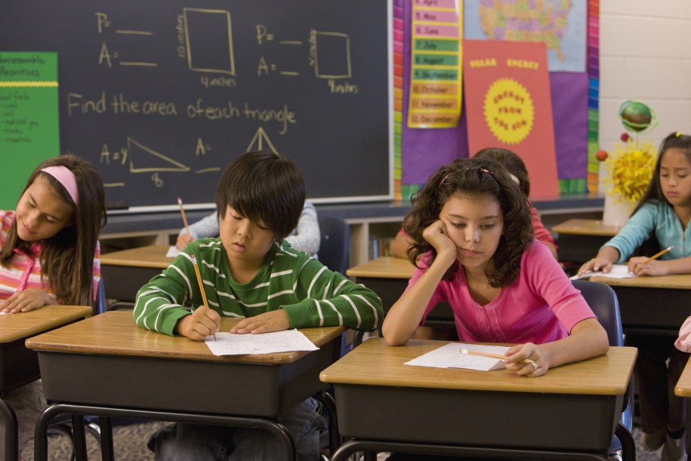 Students being held late in a classroom after the bell rings.