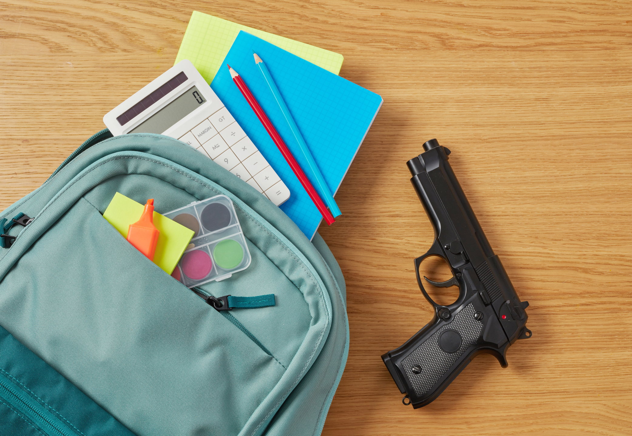 A handgun among school supplies in a backpack.